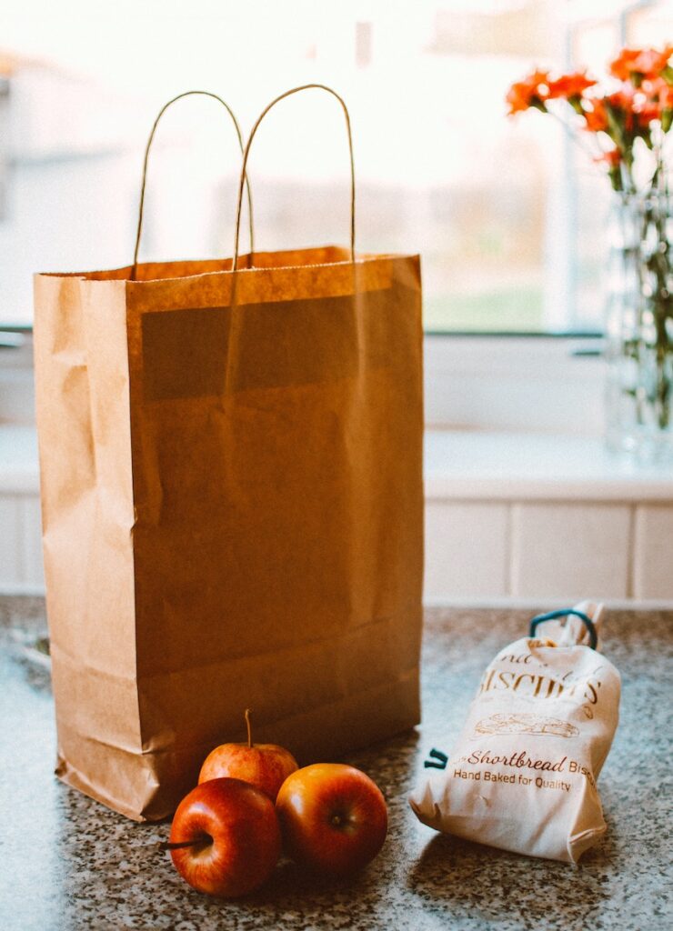 Several Apples Beside Bread Pack And Brown Paper Bag vs gift boxes