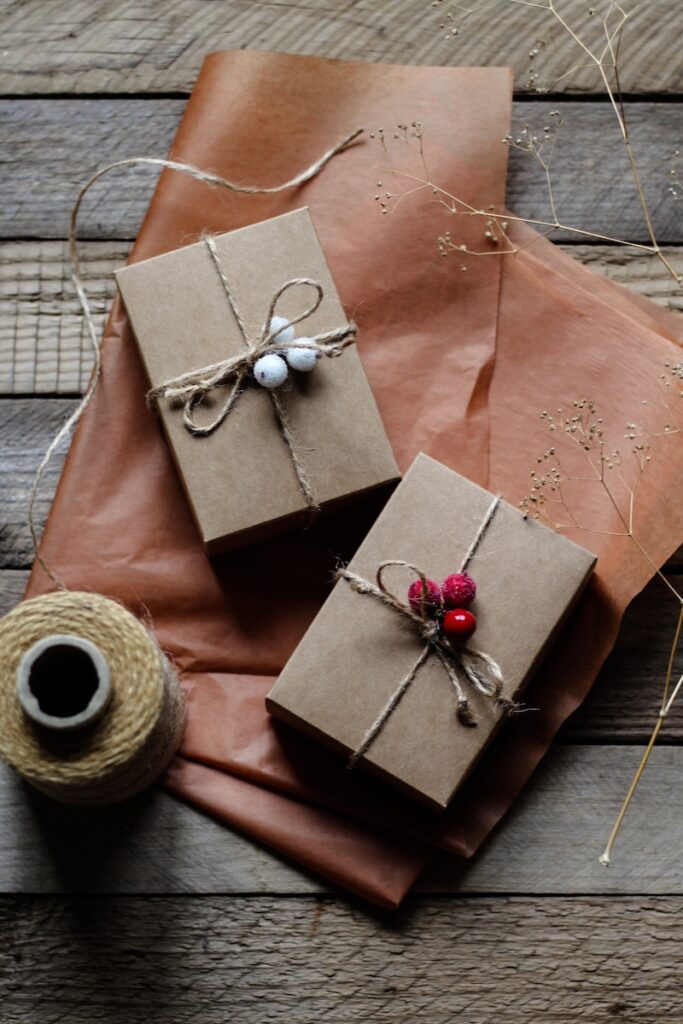 two wrapped presents sitting on top of a wooden table gift boxes