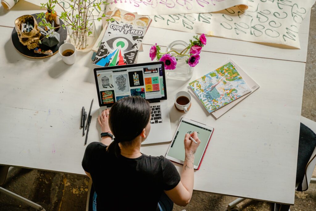 Photo of Woman Writing on Tablet Computer While Using Laptop - start a business