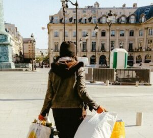 woman in black jacket and white skirt walking on sidewalk during daytime - consumer behavior - marketing research techniques