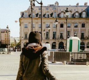 woman in black jacket and white skirt walking on sidewalk during daytime - consumer behavior - marketing research techniques