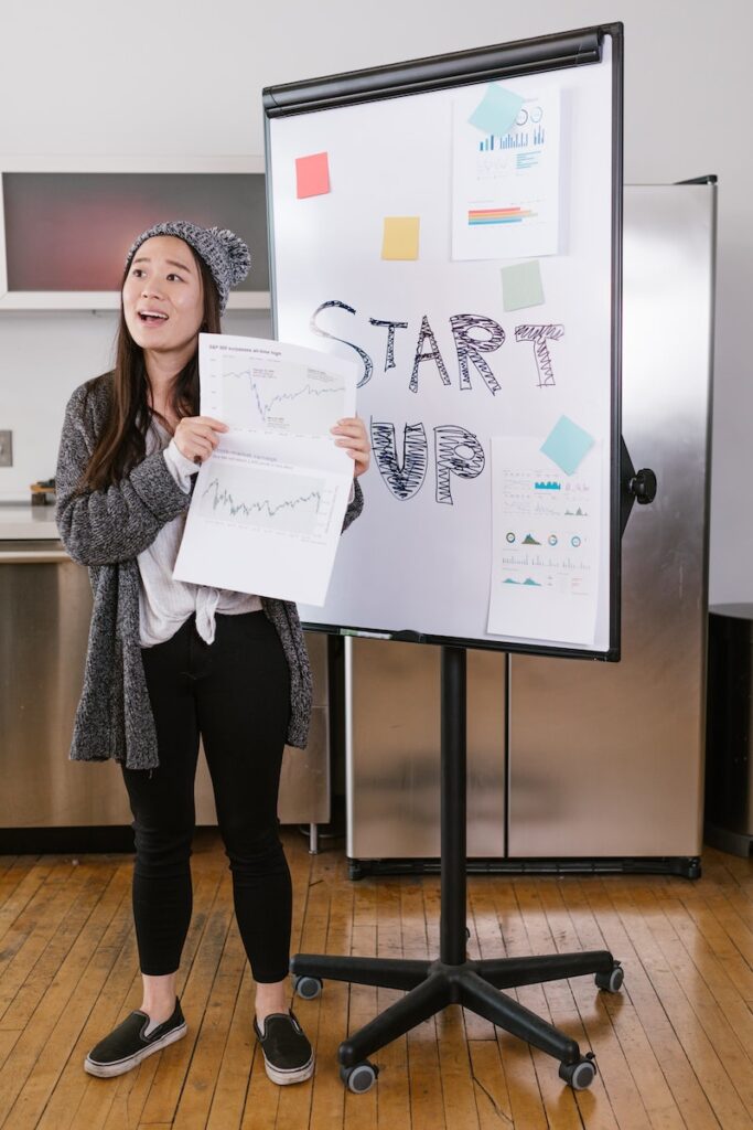 Woman in Gray Coat Holding White Printer Paper - Startups