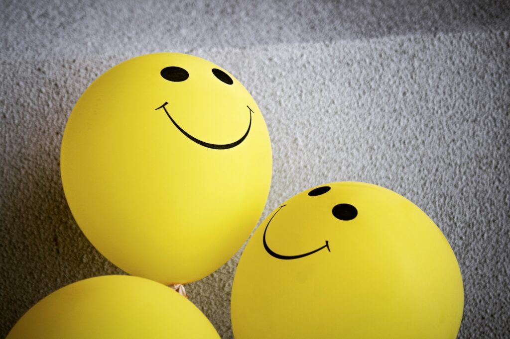 yellow smiley emoji on gray textile - positive feedback - business case studies