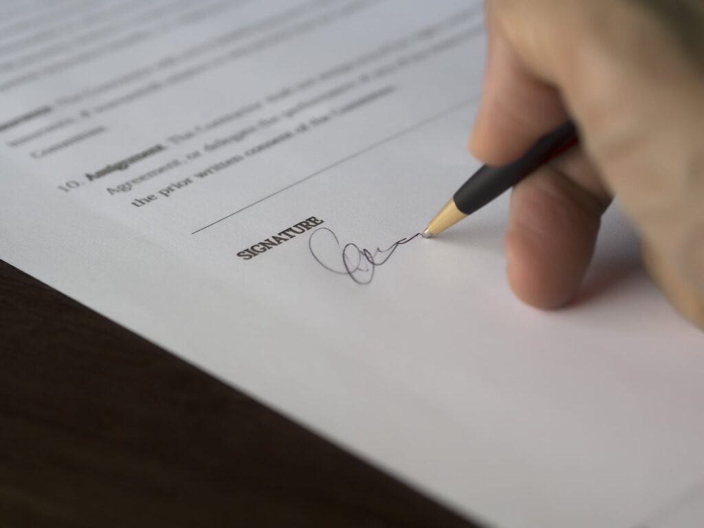 Selective Focus Photography of Person Signing on Paper - 
How to Write a Business Letter