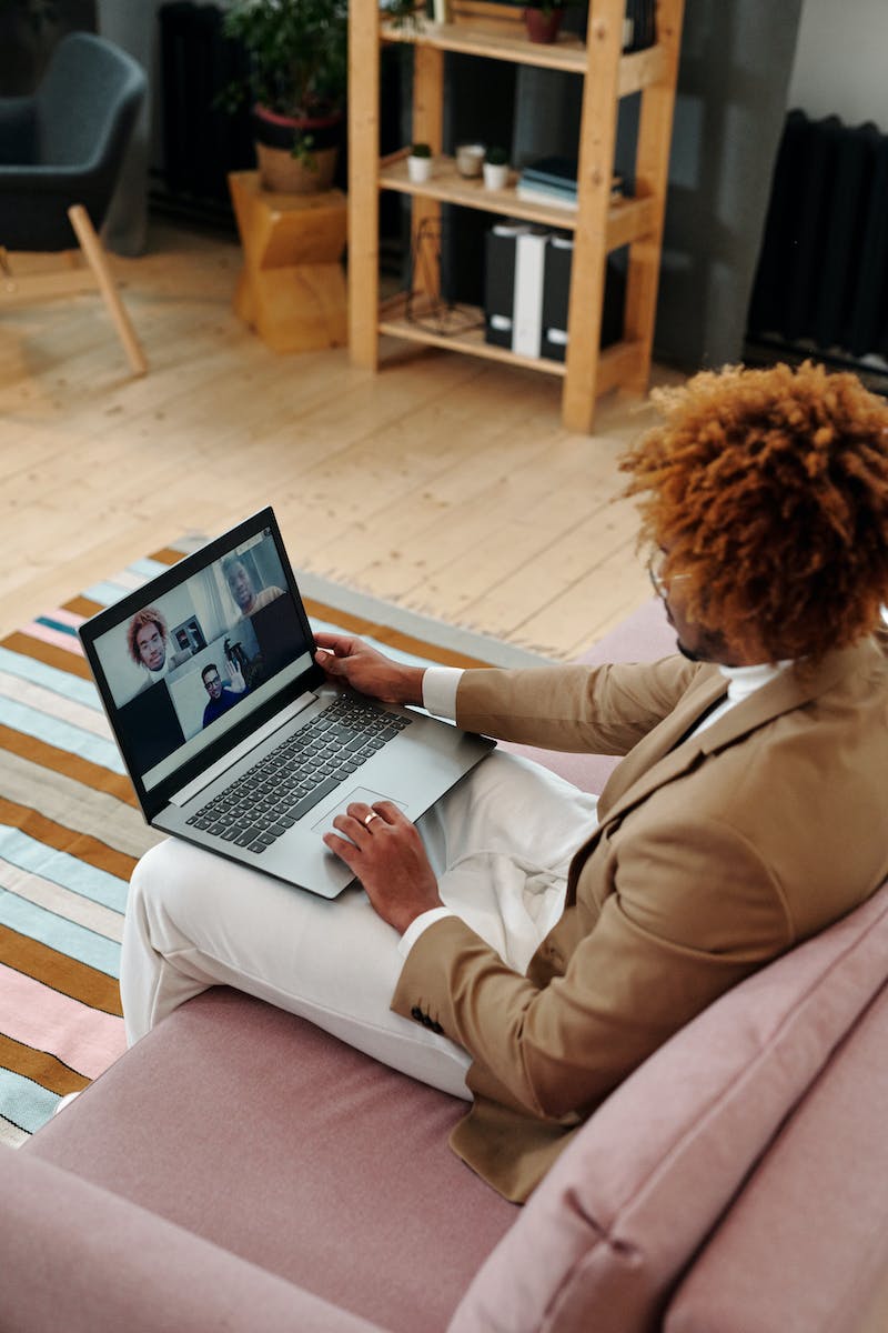 Man Sitting on Couch Talking on Webcam on Laptop Remote Communication