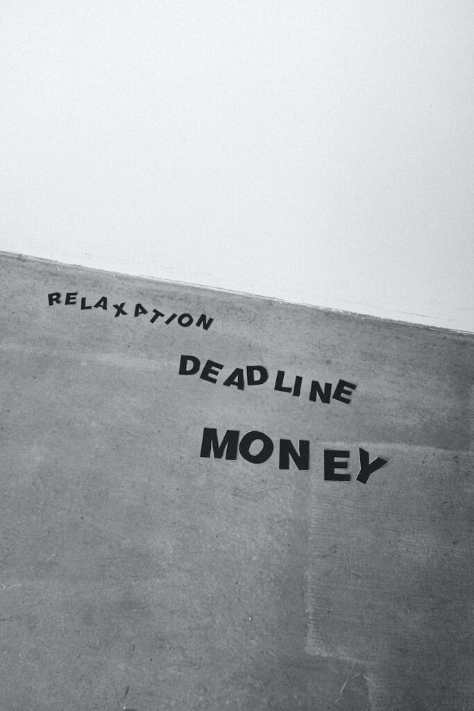 Black and white from below background of Relaxation Deadline and Money titles on gray wall - time management work from home