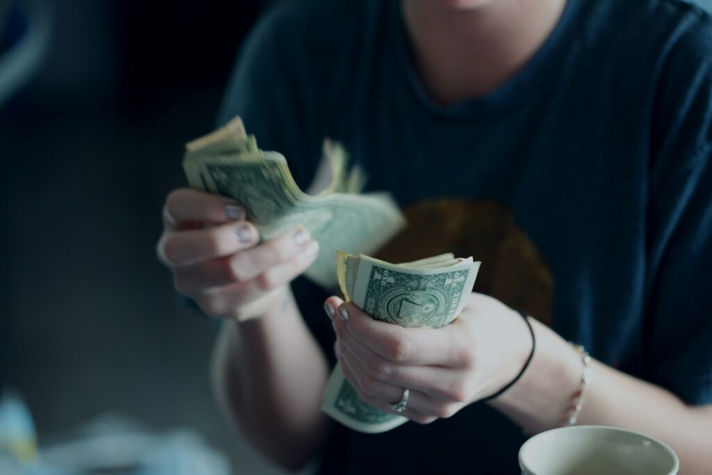 focus photography of person counting dollar banknotes - starting a small business income stream
