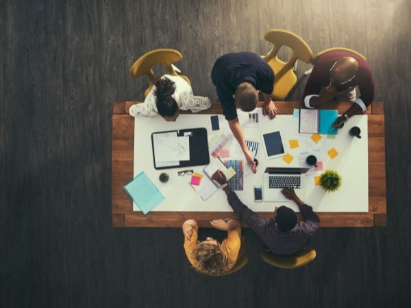 Manage Small Business Operations 2 a team sitting around a table to manage small business operations